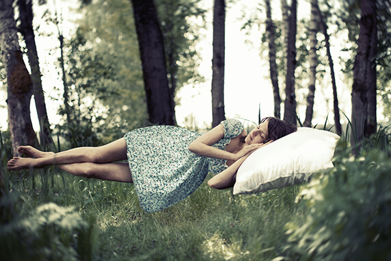 Chica acostada, flotando en la naturaleza