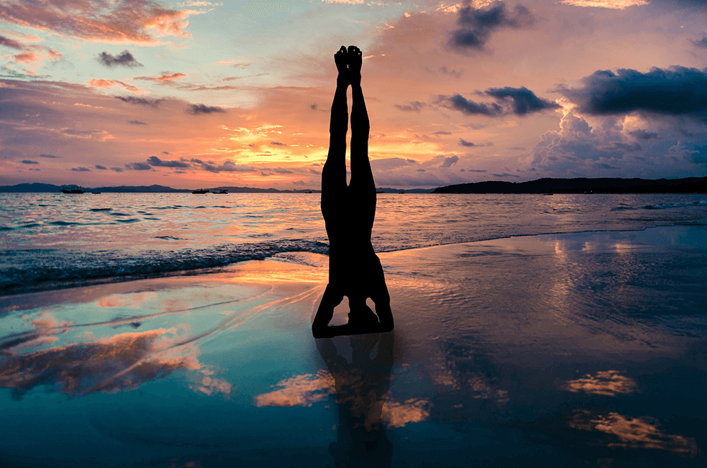 Persona practica mindfulness yoga en la playa al atardecer