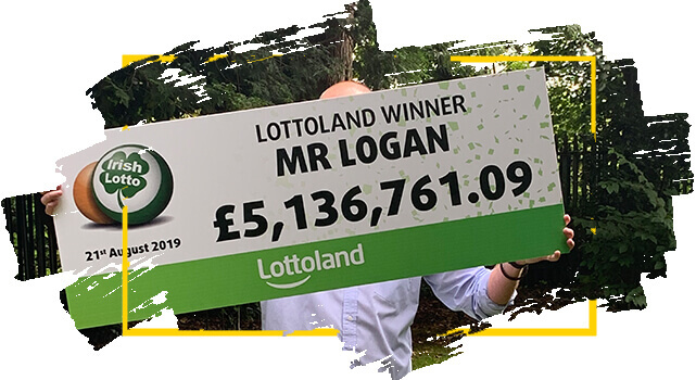 El Ganador de Lotoland  Mr Logan sostiene cheque con el premio que ganó con la Irish Lotto