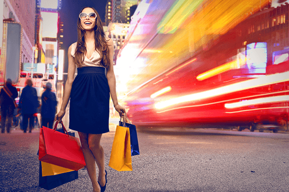 Mujer  con vestido hace sus compras en una calle lujosa