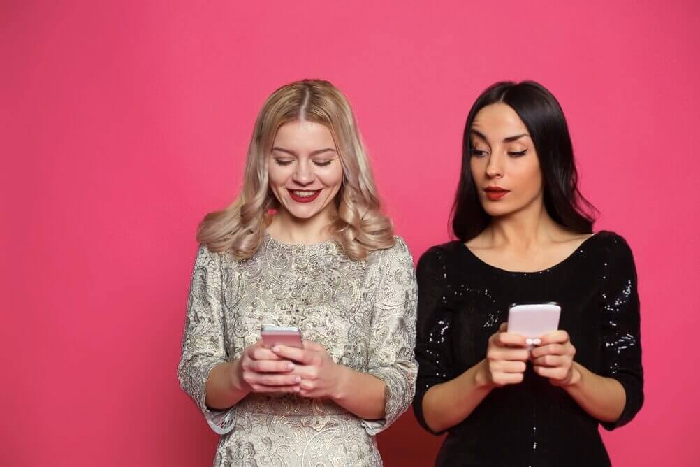 Dos  chicas revisan sus  celulares