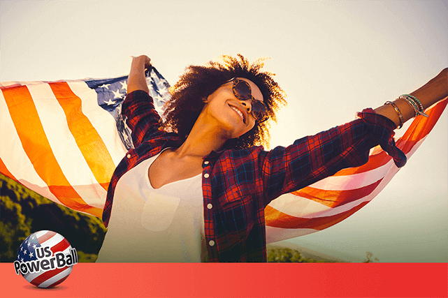 Mujer  sostiene alegre la bandera  de  estados unidos  al aire libre