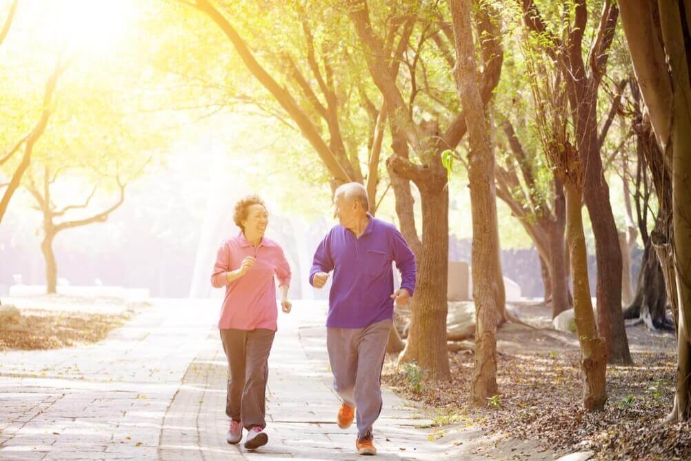 Pareja de ancianos  trotan en un parque