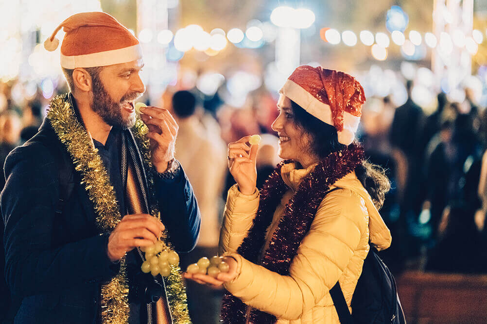 Dos personas comiendo uvas en Año Nuevo